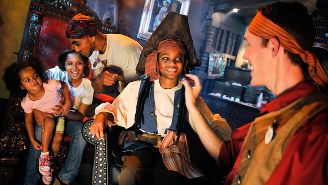 Mom and daughter watch as Dad and son get a pirate makeover at the Pirates League