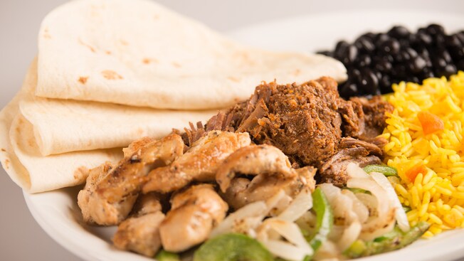 A plate of chicken, bell peppers, black beans and rice