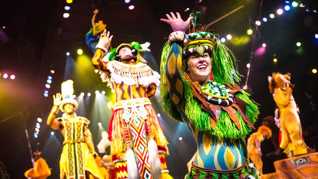 Costumed performers from Festival of the Lion King wave from the stage