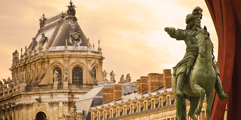 A statue of a man on a horse at the ornate Château de Versailles