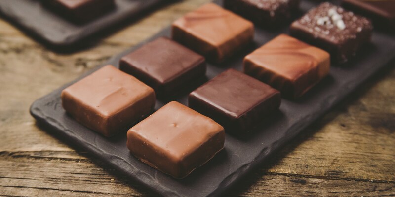 An assortment of 8 pieces of chocolate sits on a tray