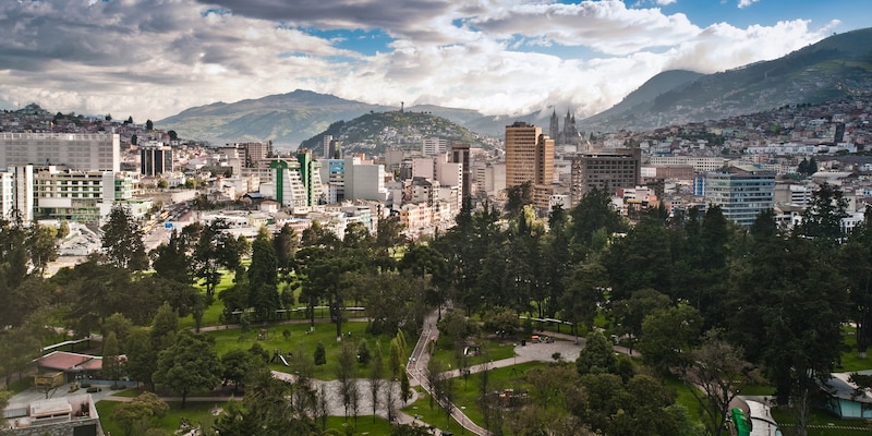 A park at the heart of downtown Quito, Ecuador surrounded by mountains and clouds