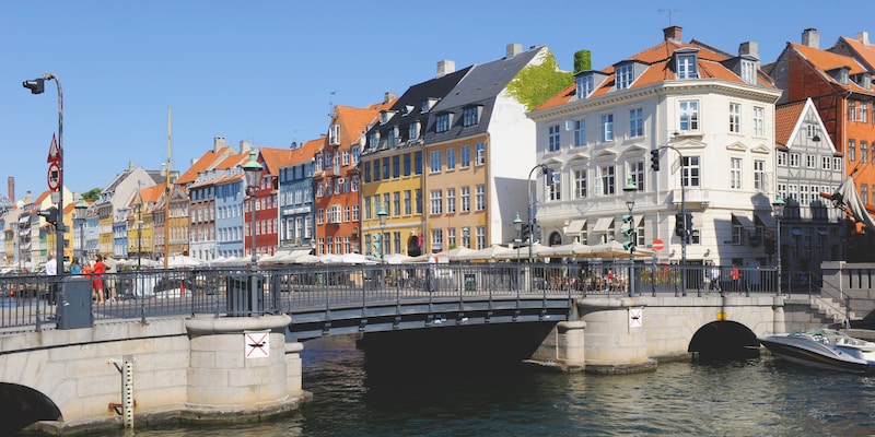 A bridge over a waterway with European buildings on one side