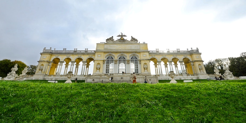 Looking up at Schönbrunn Palace from the bottom of a grassy hill