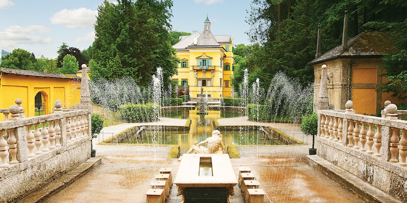 A fountain at Hellbrunn Palace sprays streams of water near a reclining statue