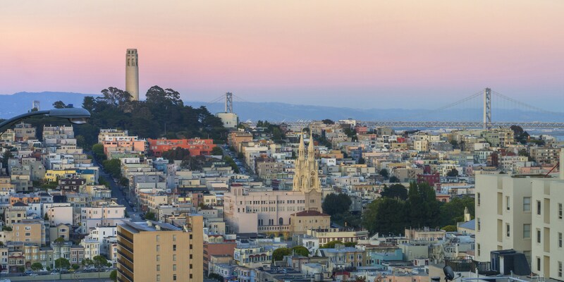 San Francisco at dusk, featuring the Coit Tower and Bay Bridge