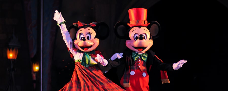 Mickey and Minnie dressed in their holiday finest, waving hello